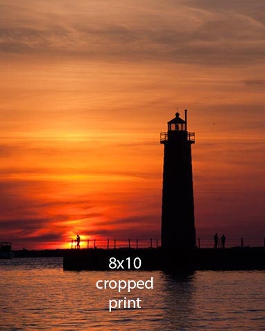 A Lone Fisherman and the Muskegon Lighthouse are Silhouetted by the Setting Sun Fine Art Photo